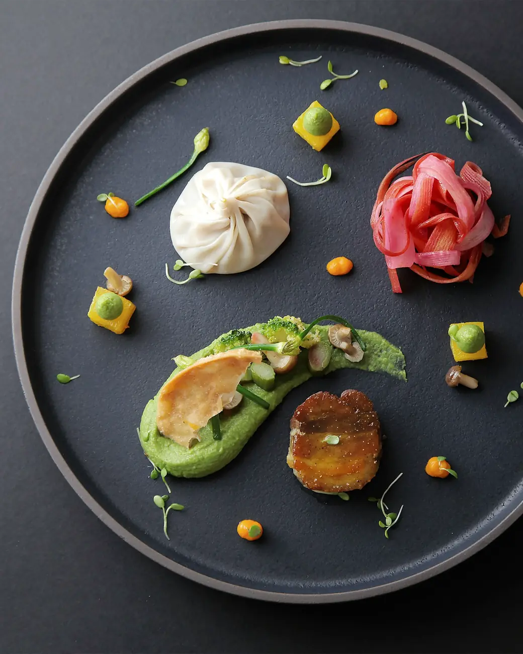 A tasting-menu course on a dark plate